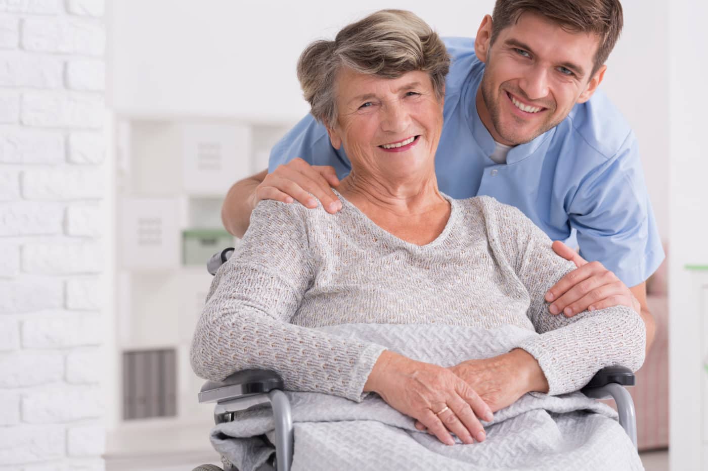 Senior care assistant with cheerful disabled woman in nursing home
